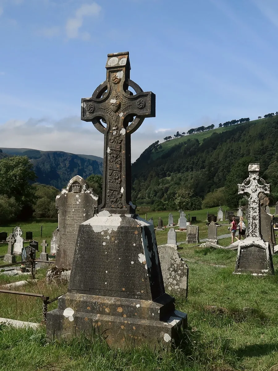 Old Celtic crosses in a graveyard, with green hills behind
