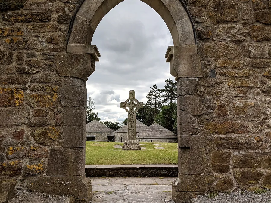 A stone church doorway framing a carved high cross at Clonmacnoise