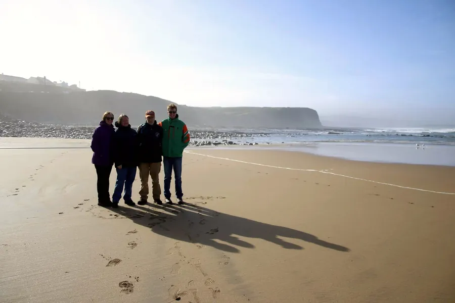 Mairéad and three family members standing together on the beach at Lahinch, with cliffs behind