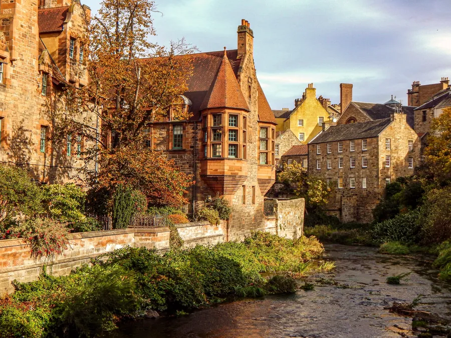 Old stone houses and autumn trees along the Water of Leith in Dean Village, Edinburgh