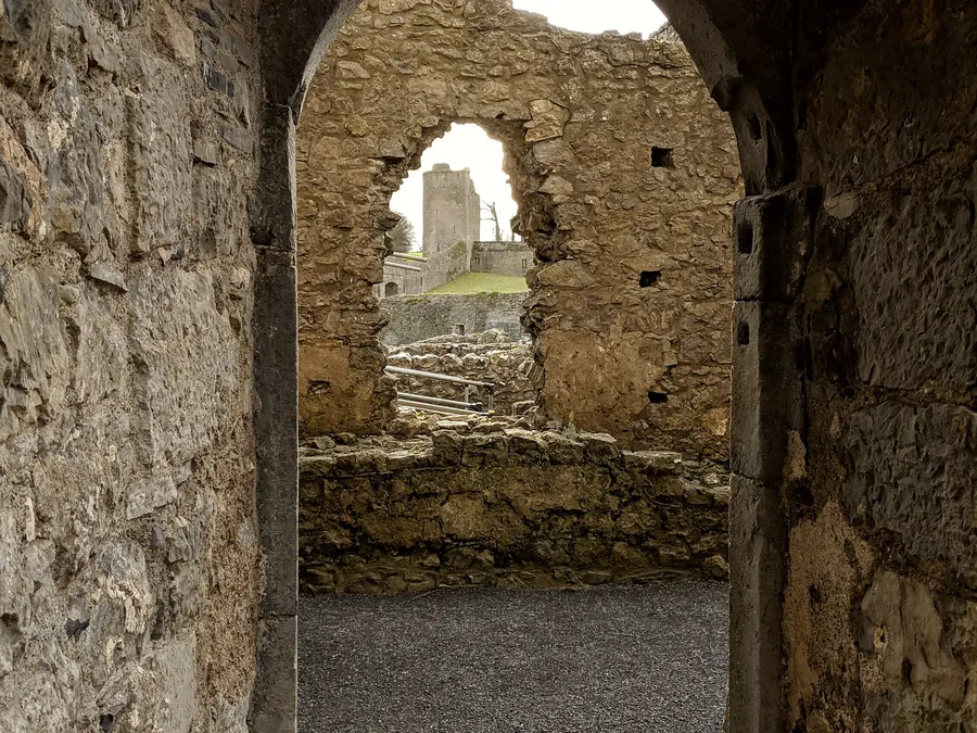 A stone archway in an old ruin at Kells, framing more ruins beyond