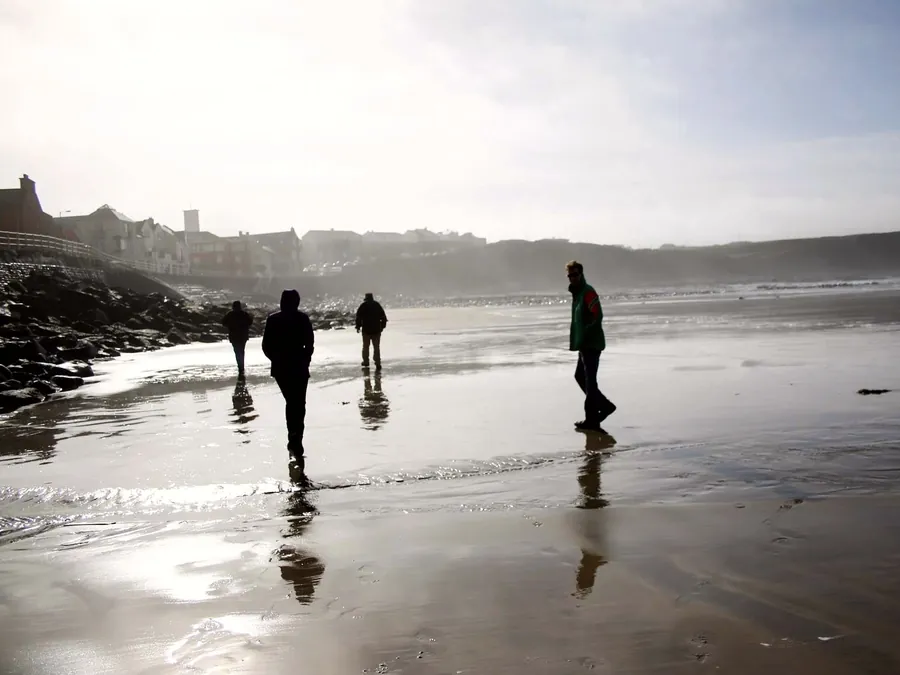 Mairéad's family walking along the misty beach at Lahinch